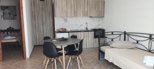 a bedroom with a bed and a table and chairs at Chrysiis House 1 in Maltezana