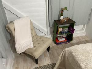 a chair with a towel on it next to a table at Adella's Blue Mountain Coffee Farmstay in Kingston