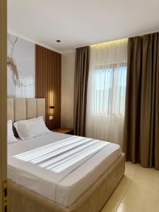 a bedroom with a large bed and a window at Kamberi Hotel & Apartments in Velipojë +208 photos