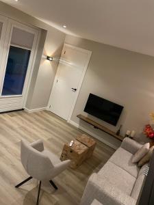 a living room with a couch and a tv at Studio 137 in Zwaag
