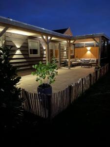 a house with a porch at night with lights at Studio 137 in Zwaag +6 photos