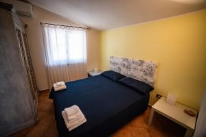 a bedroom with a blue bed in a yellow room at Villa sul mare in Parghelia +32 photos