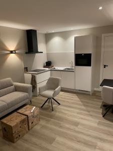a living room with a couch and a kitchen at Studio 137 in Zwaag