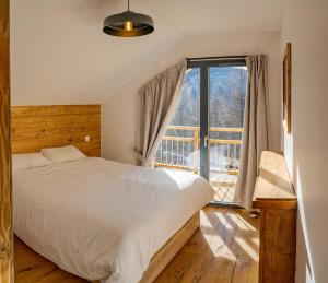 a bedroom with a bed and a large window at Chalet du Trappeur in Les Orres
