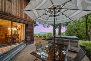 a patio with a table and an umbrella at Catskill Estate epic views hot tub in Kingston