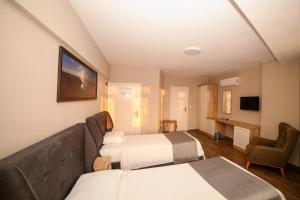 a hotel room with two beds and a couch at İmroz Elia Hotel in Gokceada Town
