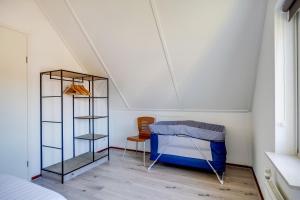 a bedroom with a bed and a chair in a room at Koekoek I Modern Huis met Privé Tuin in Zwiggelte