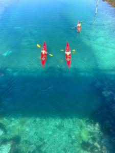 a group of three kayaks floating in the water at Nykmark - Eco House - Room Selva in Bøstad