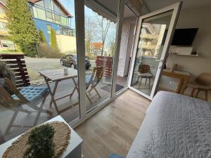a room with a balcony with a table and chairs at Mėlynas krantas in Juodkrantė