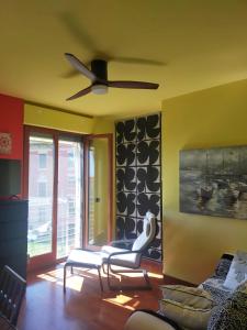 a living room with a ceiling fan and a couch at Dreaming of the Sea Albenga View in Albenga