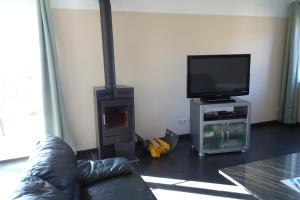a living room with a couch and a flat screen tv at Au coin de détente in Durbuy