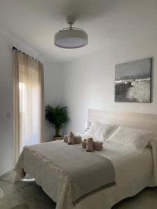 a bedroom with a large bed with two stuffed animals on it at Apartamento Capillera 9 in El Puerto de Santa María