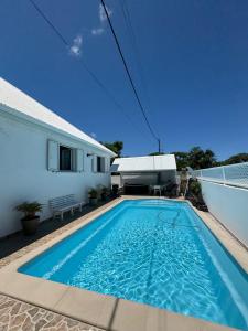 a swimming pool in front of a house at Le PalaSud in Saint-Joseph