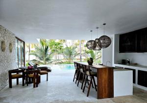 a kitchen and dining room with a table and chairs at Shungi Villa Zanzibar Trips Included from 3 nights in Tongoni