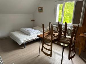 a room with a bed and a table and chairs at Le tourbillon in La Bourboule