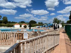 a wooden fence next to a swimming pool at Vue lac à 5 minutes de la mer in Talmont