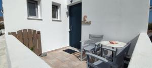 a small table and chairs on a patio with a door at Chrysiis House 2 in Maltezana