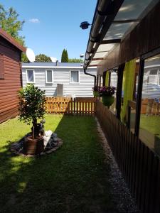 a backyard with a fence and a potted tree at Mobilheim Chalet Chicco in Steinach