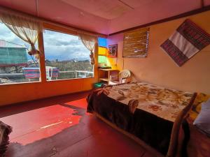 a bedroom with a bed and a large window at Uros Casa de Yolanda in Puno