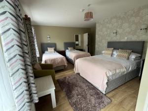 a bedroom with two beds and a couch at Killilagh Accommodation in Doolin