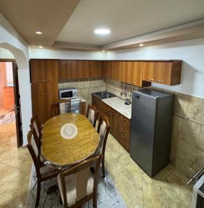 a kitchen with a wooden table and a refrigerator at Villa Miki in Kruče