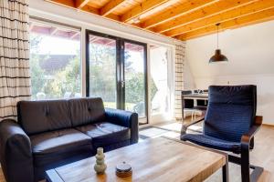 a living room with a couch and a table at Nachtegaal I Vakantiewoning met Mooie Tuin in Zwiggelte