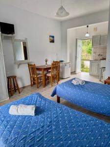 a room with two beds and a table with a kitchen at Irene Studios in Arillas