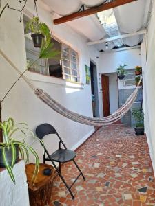 eine Hängematte in einem Raum mit einem Stuhl und Pflanzen in der Unterkunft Casinha na Vila Madalena in São Paulo