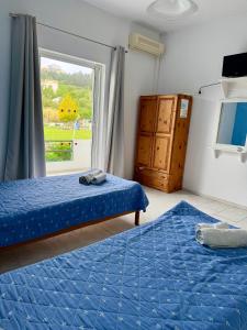 a bedroom with two beds and a window at Irene Studios in Arillas