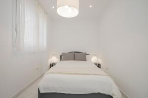 a white bedroom with a bed and a window at NEW! Stunning modern 2BR apt next to Feria in Seville