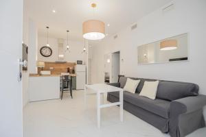 a living room with a couch and a table at NEW! Stunning modern 2BR apt next to Feria in Seville +26 photos