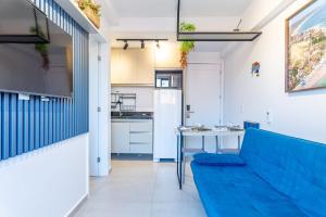 a living room with a blue couch and a table at Flat no Centro 1 Quarto com varanda - 50m Piscinas das Naturais in Porto De Galinhas