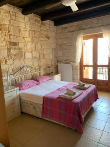 a bedroom with a large bed in a stone wall at Villa Anatoli in Epáno Kefalás