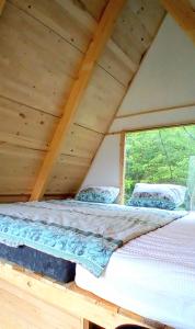 a bed in a wooden room with a window at Mountain View 2 in Foča