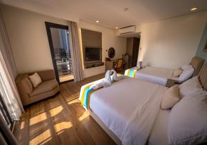 a hotel room with two beds and a couch at Magarra Hotel in Orani +32 photos