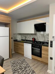 a kitchen with white cabinets and a black stove top oven at My Trabzon trend house in Trabzon +17 photos