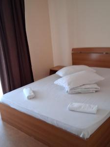 a bed with white sheets and two white pillows at Pensiunea Krystinne in Peştişu Mare
