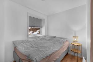 un lit dans une chambre blanche avec une fenêtre dans l'établissement 2-bedroom modern apartment in Tromsø, à Tromsø 7 autres photos
