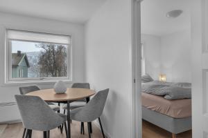 une pièce avec une table, des chaises et un lit dans l'établissement 2-bedroom modern apartment in Tromsø, à Tromsø