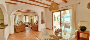 Villa Tia by Solidays في مورايرا: غرفة معيشة مع طاولة وكراسي زجاجية