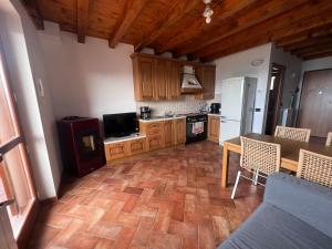 a kitchen with wooden cabinets and a table and a kitchen with a tableablish at Relax con vista in Costa Valle Imagna