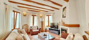 Villa Tia by Solidays في مورايرا: غرفة معيشة مع أريكة ومدفأة