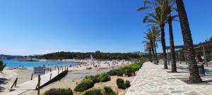 Villa Tia by Solidays في مورايرا: شاطئ فيه نخيل وناس على الشاطئ