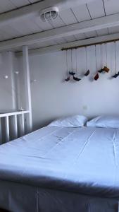 a bed in a room with shoes hanging from the ceiling at Houses of chora in Serifos Chora +16 photos