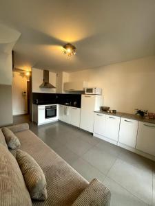a kitchen with white cabinets and a couch in a room at Apartment Propriano, Corsica in Propriano
