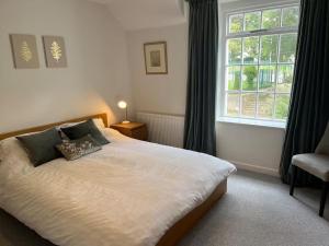a bedroom with a large bed with a window at Charming 3-Bed Cottage - Private Garden & Parking in Torquay
