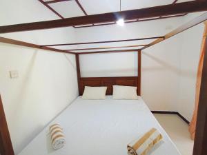 Cama pequeña en habitación con techo en Benefit Villa Mirissa, en Mirissa