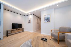 Una sala de estar con un televisor, un sofá y una mesa. en Mayer Skycon Residence in Beşiktaş 2, en Estambul