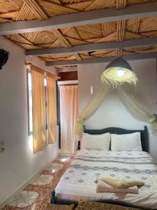 Un dormitorio con una cama con techo de madera. en Etoile d Or Ksar Ait Ben Haddou, en Aït Ben Haddou