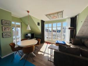 蒂门多弗施特兰德路易莎公寓式酒店的客厅里有一张桌子和一张沙发